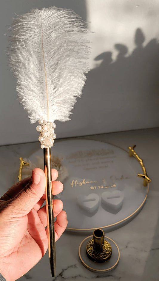 Close-up of luxury white feather bridal pen with gold base and pearl detailing for Nikkah ceremony