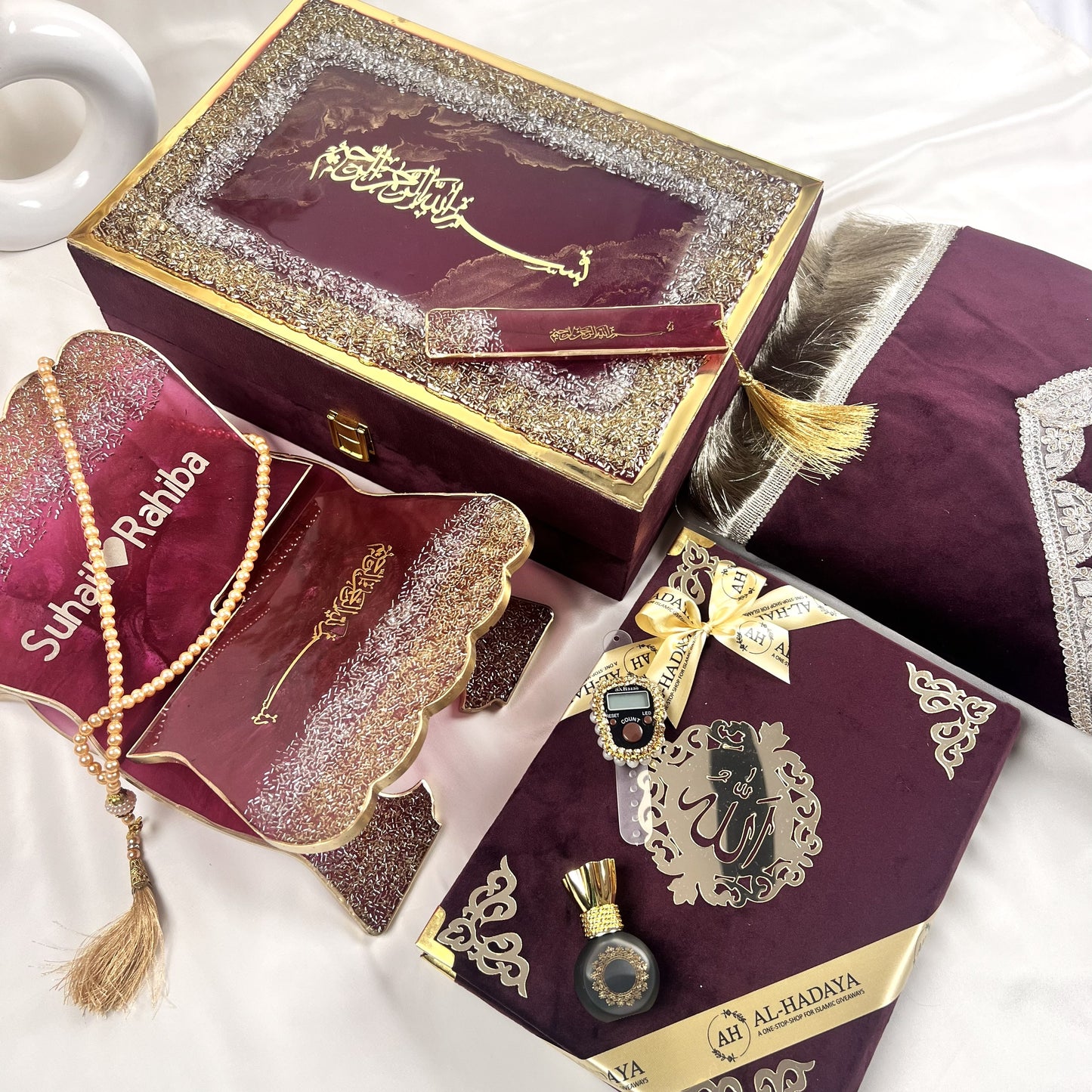Elegant wine Quran hamper with resin Quran stand, digital counter, turkish tasbeeh, halal attar, and prayer essentials.