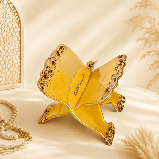 Gold bird-shaped jewelry dish on a beige background