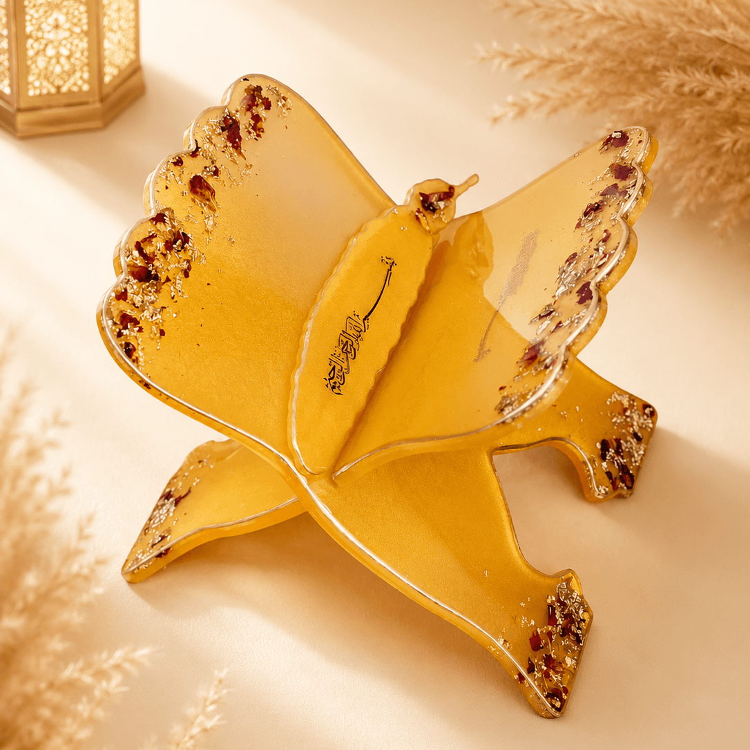 Decorative yellow bird-shaped plate with gemstone accents on a soft beige background.