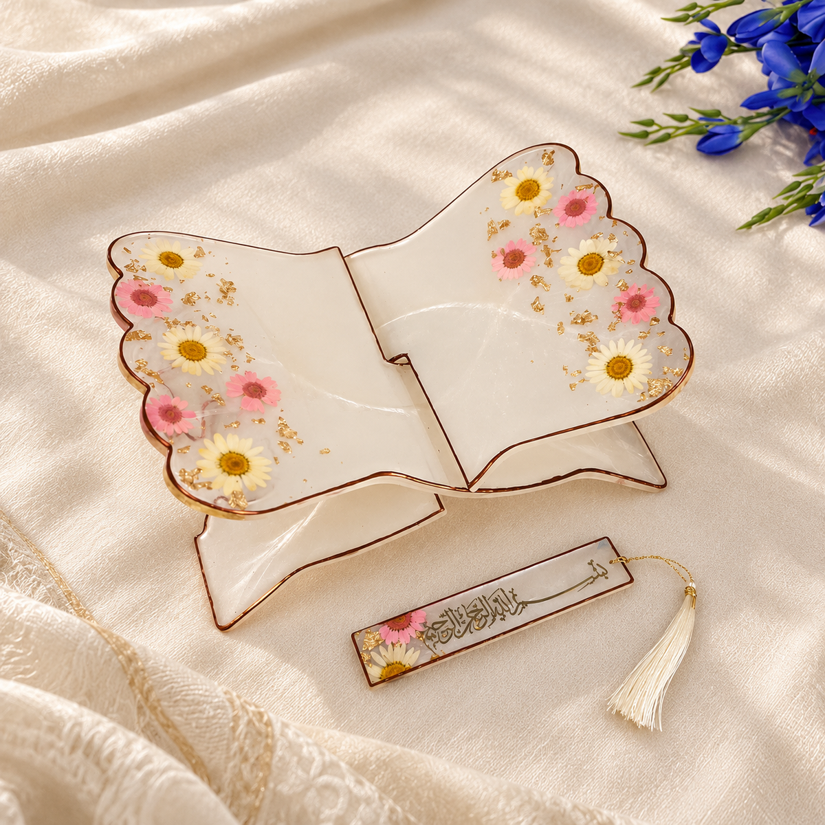 Premium floral resin Quran rehal with matching Islamic calligraphy bookmark, featuring delicate pink and white flowers, gold accents, and a cream luxury background with blue flowers.