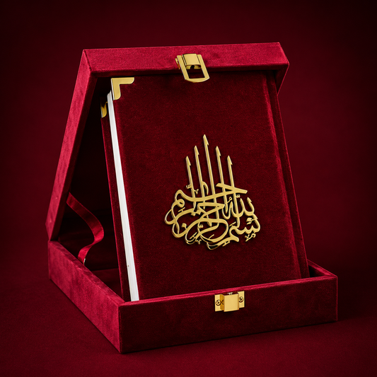 A gold-tone Islamic calligraphy plaque presented inside an open red velvet book-shaped gift box with gold corner accents and clasps, set against a dark red background.