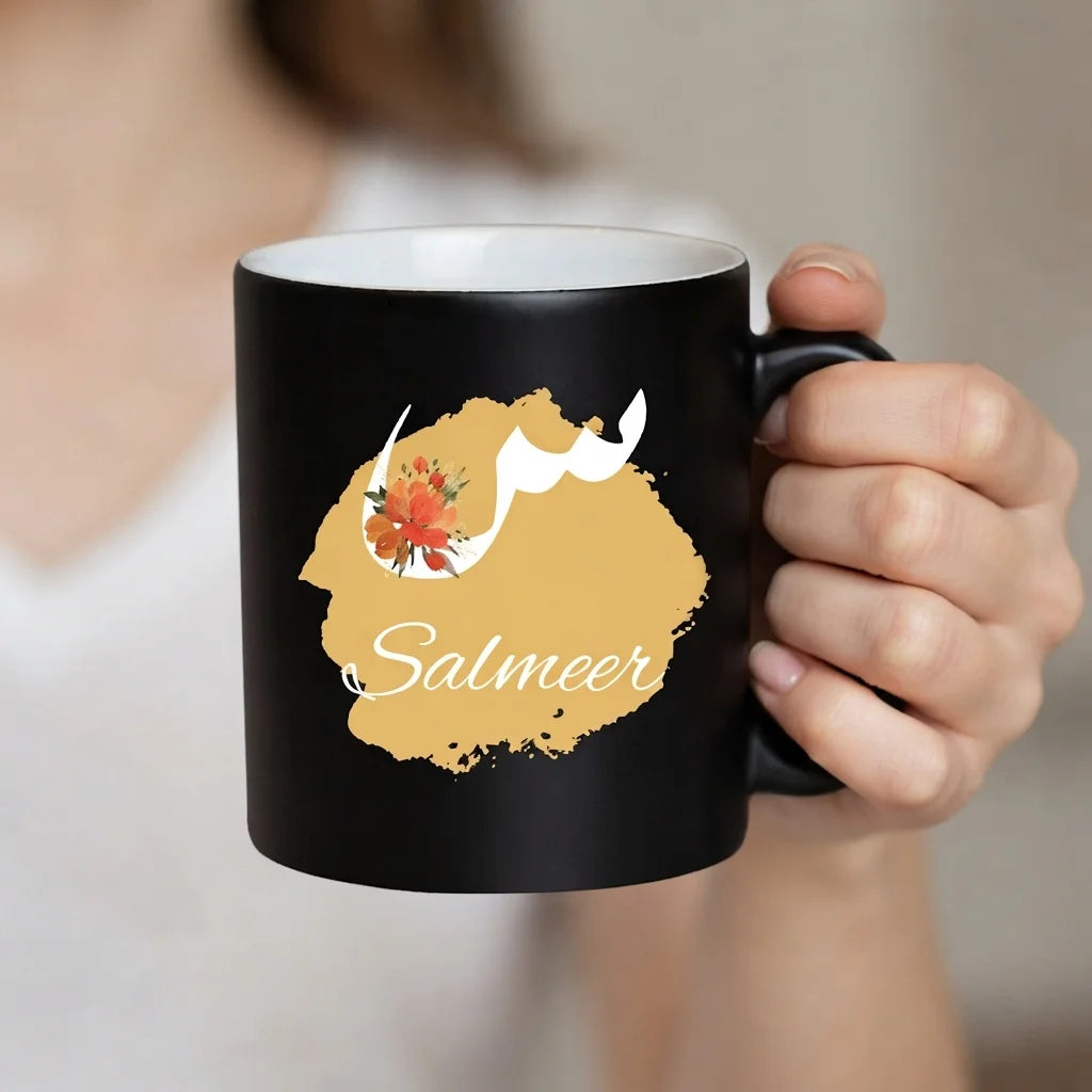 Personalized Matte Black Ceramic Mug with White Floral Arabic Initial Calligraphy and English Name Script on Gold Brushstroke