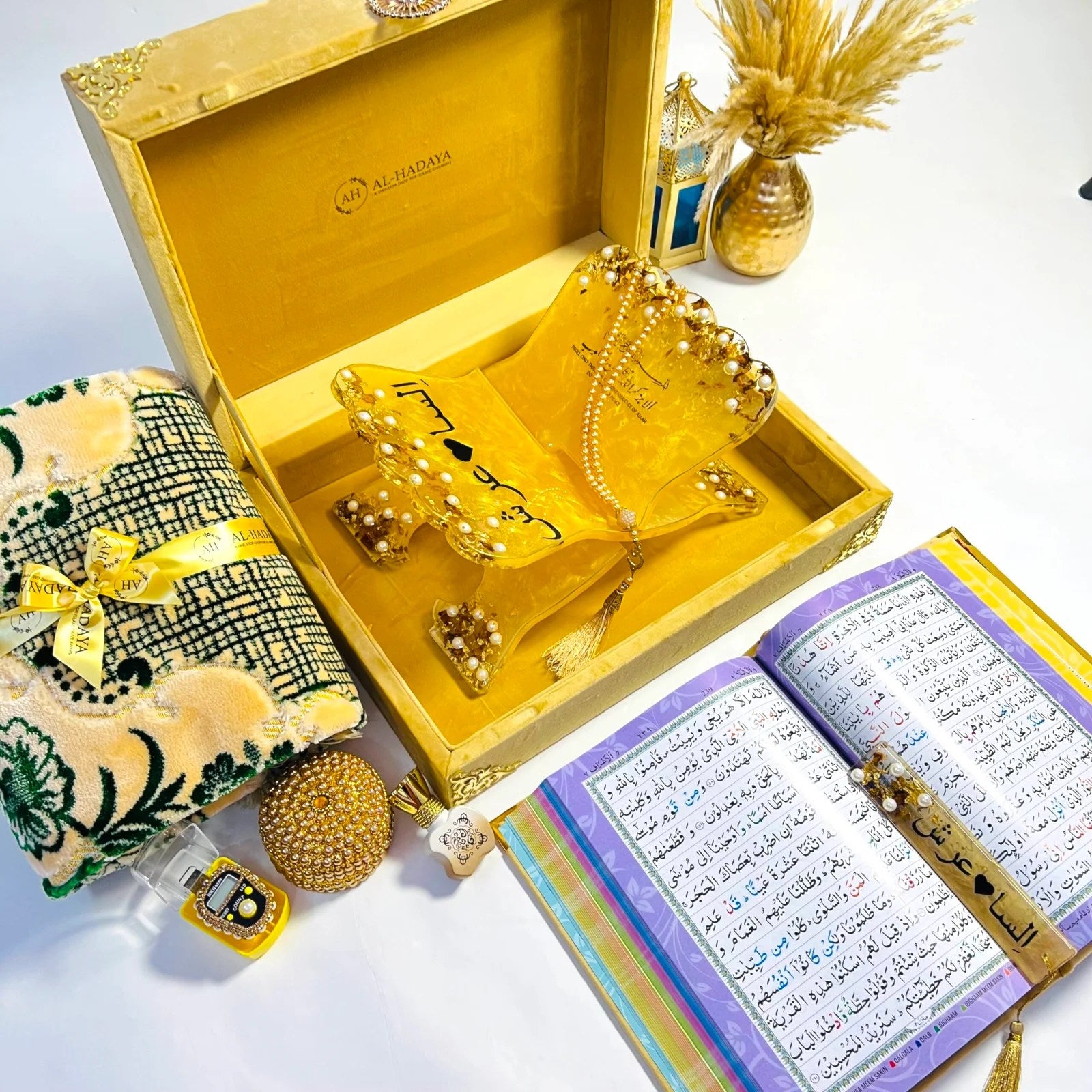 Premium golden Quran gift set from Al-Hadaya’s Hubb Al-Iman Collection featuring velvet Quran, Turkish prayer mat, tasbih, and attar.