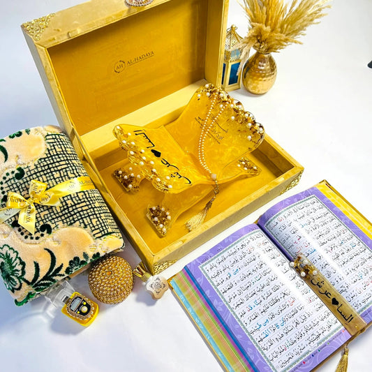 Premium golden Quran gift set from Al-Hadaya’s Hubb Al-Iman Collection featuring velvet Quran, Turkish prayer mat, tasbih, and attar.