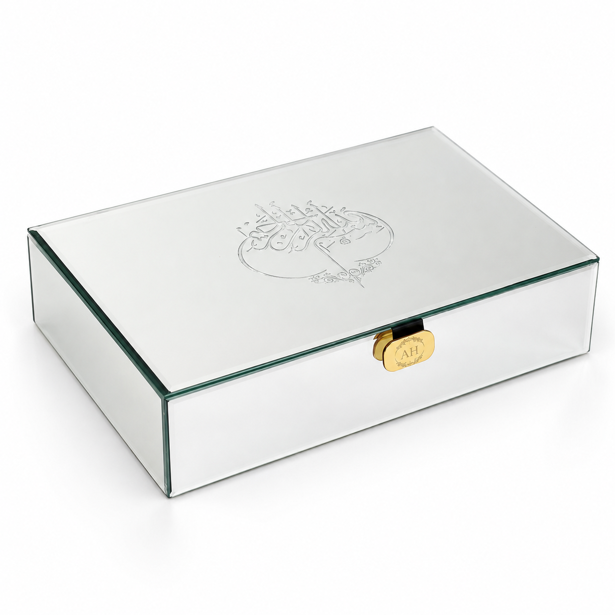 A rectangular mirrored glass keepsake box with a gold clasp and an engraved Arabic calligraphy design on the lid, shown on a white background.