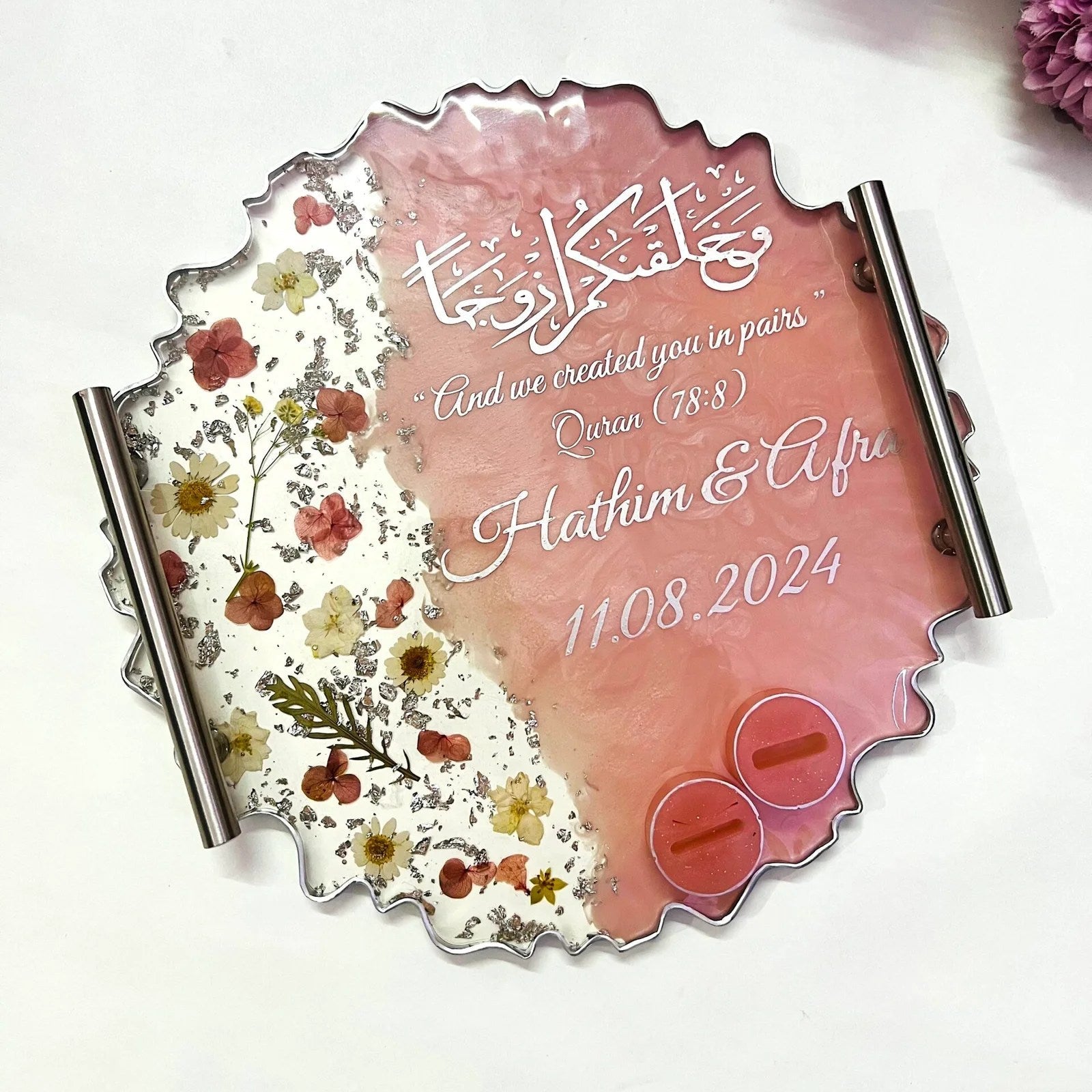 Floral resin wedding ring tray with silver accents and decorative base.