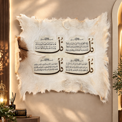 A decorative wall hanging made from off-white animal fur with four black Arabic calligraphy panels arranged in a 2x2 grid, displayed on a warm beige wall in a styled interior setting.