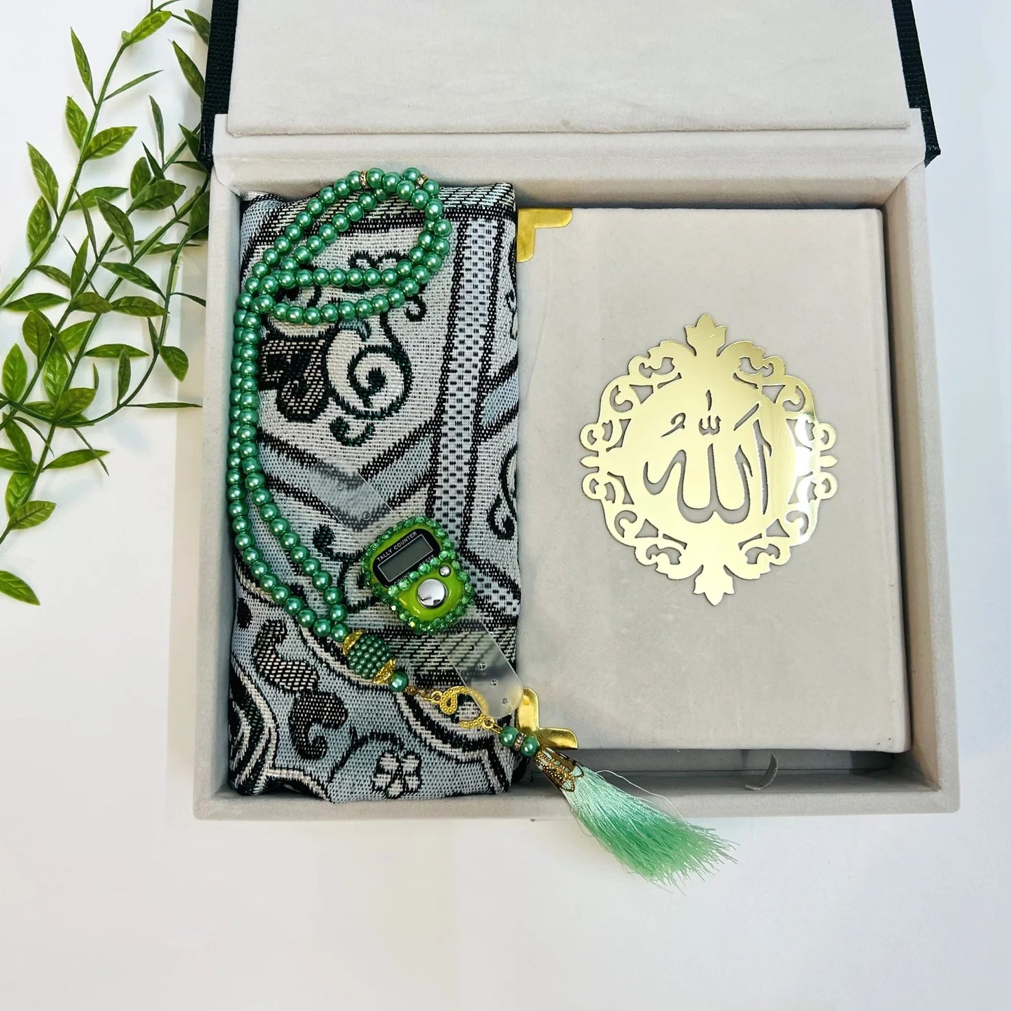 Luxury Islamic gift box in textured bottle green with velvet Quran and travel prayer rug.