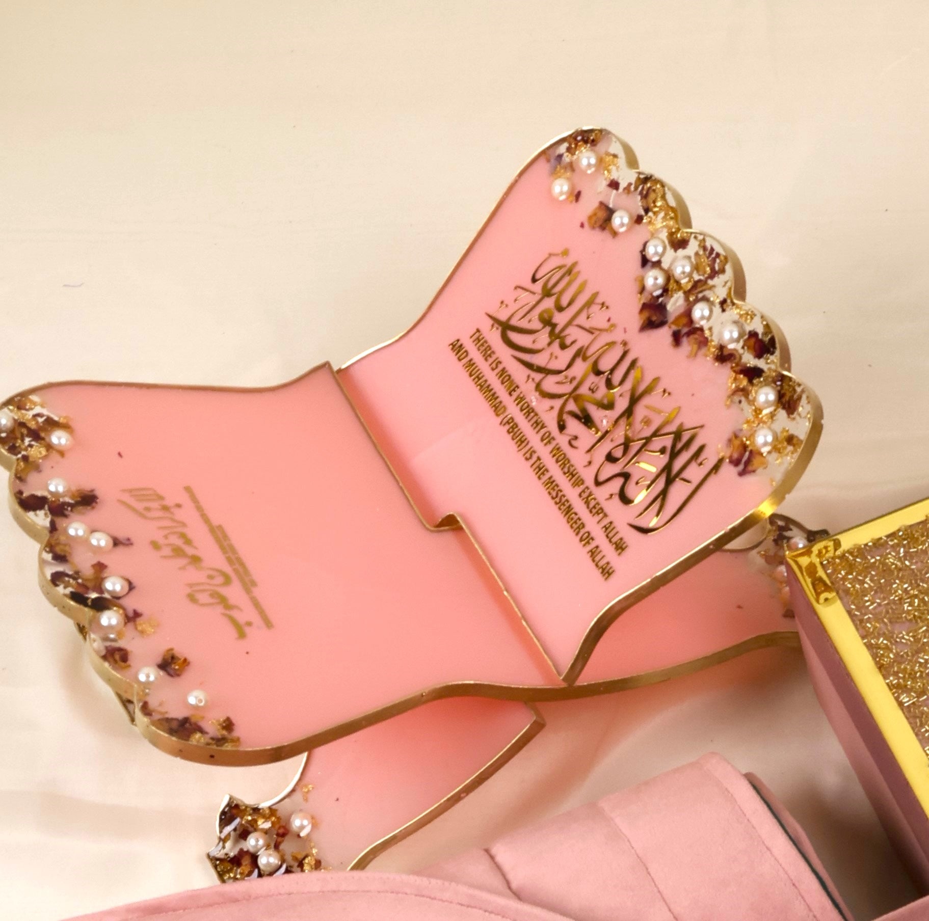 pastel pink resin rehal with shahada written on it 