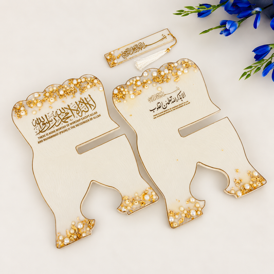 Two decorative wooden Eid Mubarak cards shaped like an elephant, decorated with gold foil, white faux pearls, and Arabic calligraphy, displayed on a white surface with blue flowers in the corner.