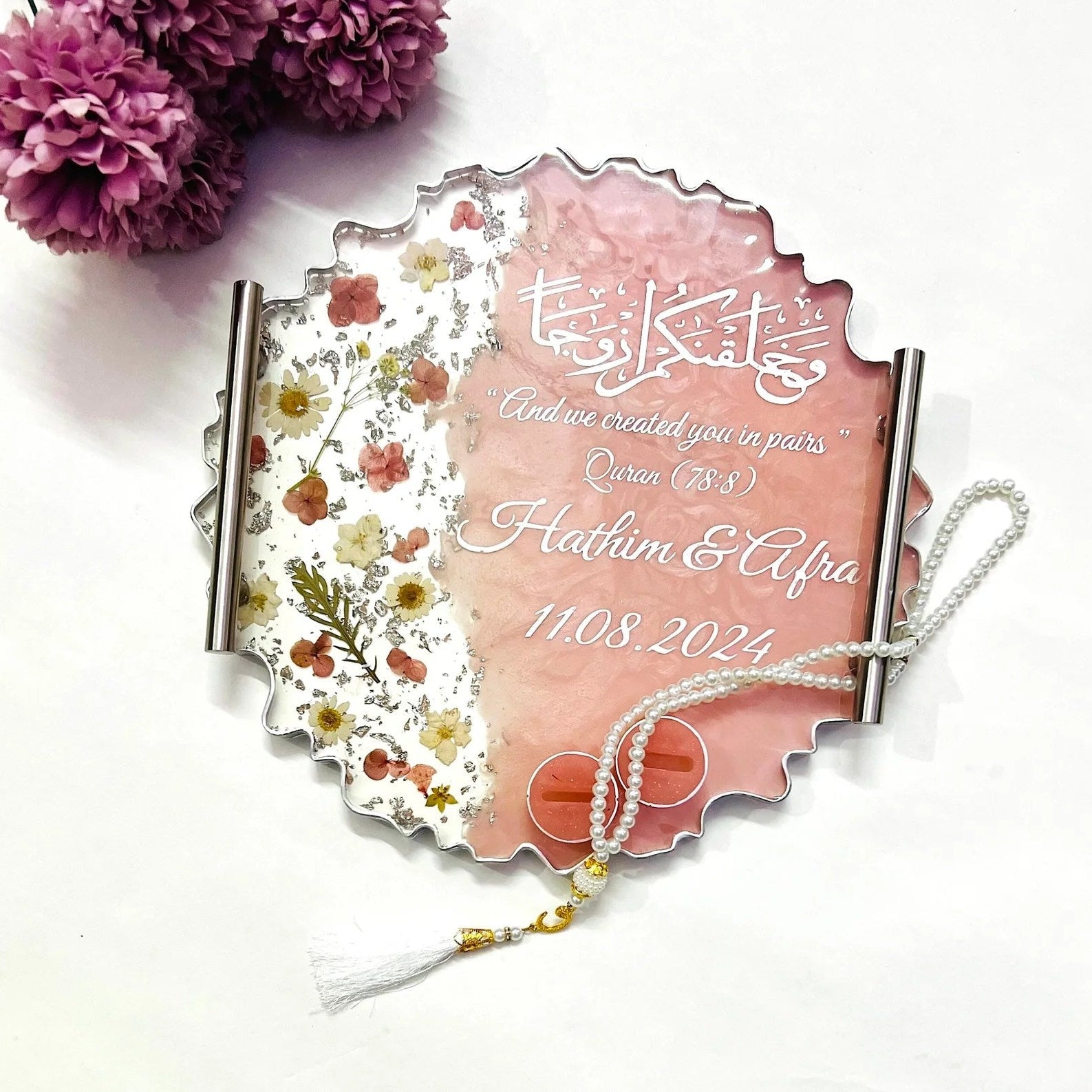 Floral resin wedding ring tray with silver accents and decorative base.