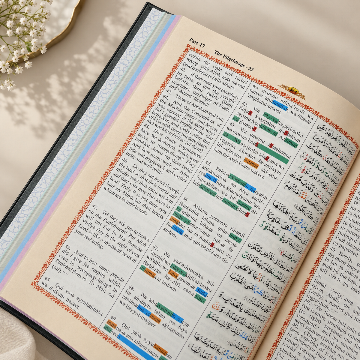 Open Quran page featuring Surah Al-Falaq and Surah An-Naas with Arabic text, English translation, Roman transliteration, colour-coded tajweed markings, and a decorative Islamic border.