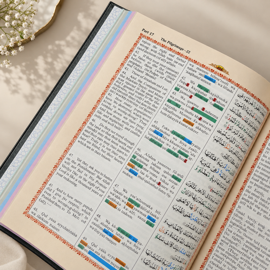 Open Quran page featuring Surah Al-Falaq and Surah An-Naas with Arabic text, English translation, Roman transliteration, colour-coded tajweed markings, and a decorative Islamic border.