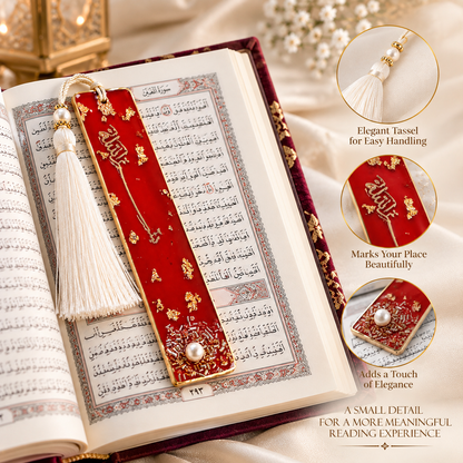A red velvet Quran bookmark with gold foil details, a white tassel, and a pearl accent, resting on an open book with Arabic script.