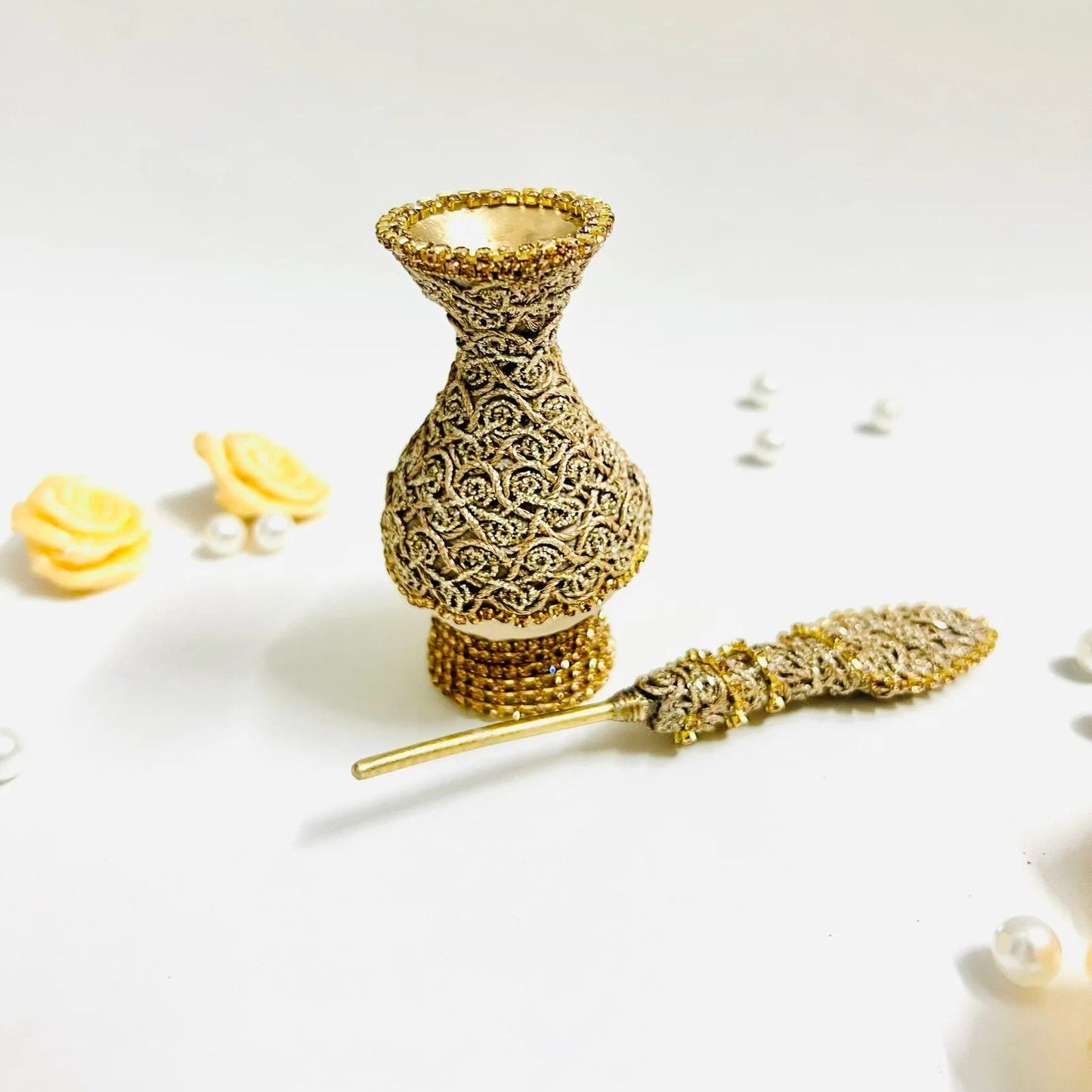 Traditional Muslim surma dani in ivory fabric and gold embellishments.