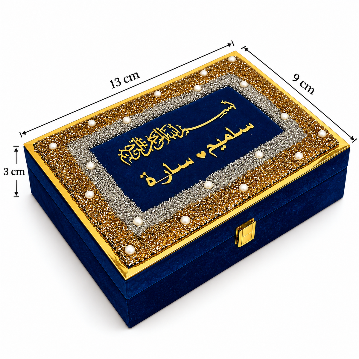 A square blue velvet jewelry box with a gold and silver beaded border and Arabic calligraphy on the lid, shown with dimension lines indicating 13 cm length, 9 cm width, and 3 cm height.