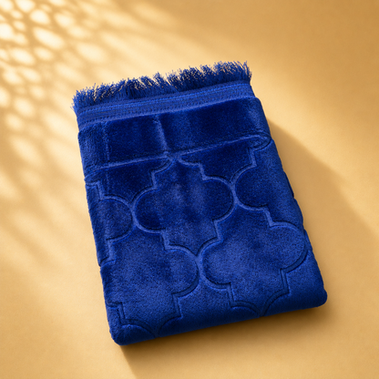 Blue textured prayer mat on a beige background