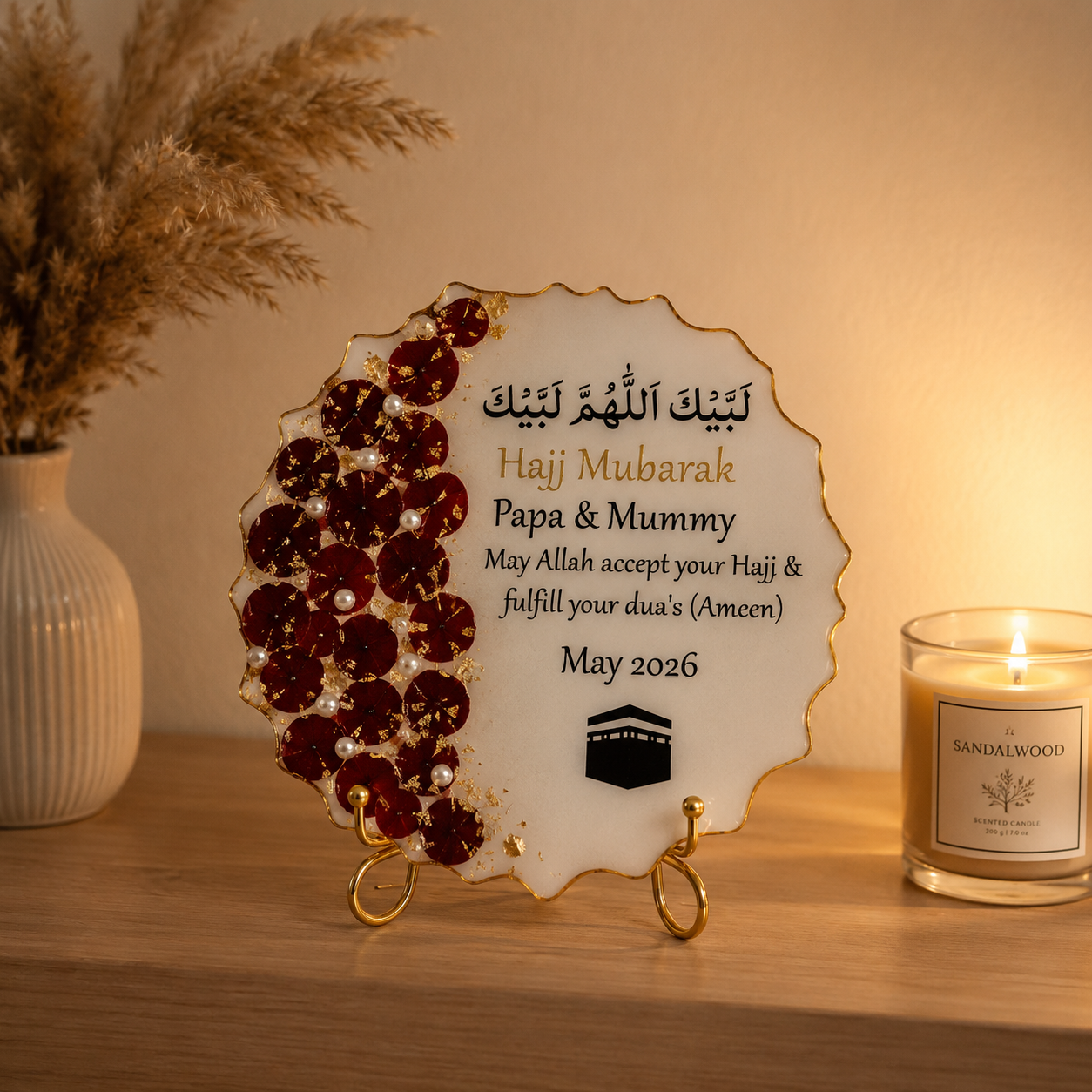 Decorative plaque with inscriptions and a candle on a wooden surface