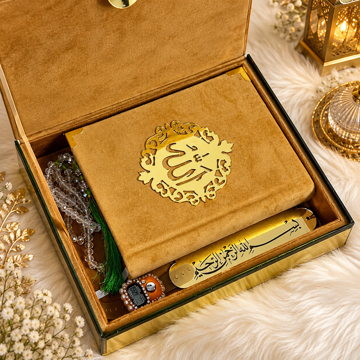 An open decorative gift box containing a tan book with a gold ornamental emblem featuring the word 'Allah', alongside prayer beads, a small tassel, and a gold pen, arranged on a white faux-fur surface with warm ambient decor.