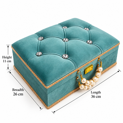 A teal velvet jewelry box with tufted buttons, crystal accents, a gold-tone clasp, and a pearl handle, shown with dimension labels for height, breadth, and length on a white background.