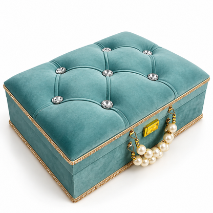A square teal velvet jewelry box with tufted button details, crystal-like rhinestone accents, a gold-tone clasp, and a pearl handle, shown on a clean white background.