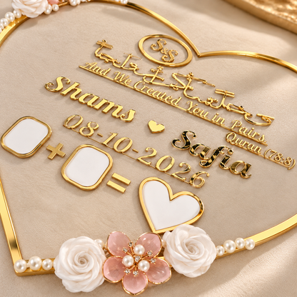 Gold-plated custom Arabic calligraphy wedding keepsake plaque set with white enamel inlays, pearl accents, and floral details on a beige satin background.
