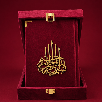 A gold metal Islamic calligraphy plaque of Ayat al-Kursi, displayed inside an open deep red velvet presentation box with gold-tone hardware.